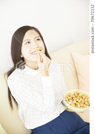 A woman eating popcorn 70672332