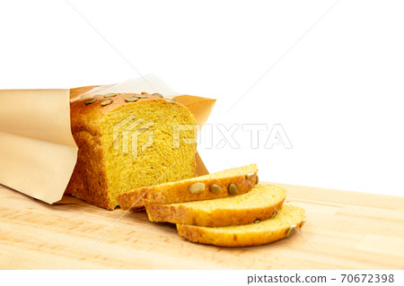 Homemade pampkinl bread with seeds in paper bag isolated on white background. Homemade pampkinl bread with seeds in paper bag isolated on white background. 70672398