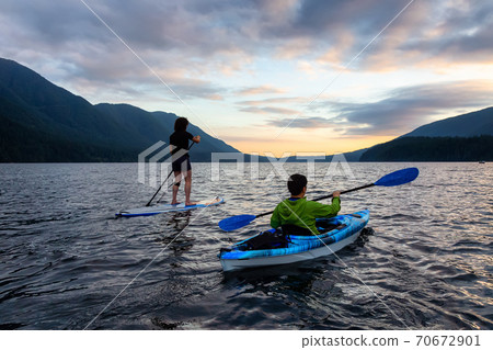Friends on Scenic Lake Kayaking and Paddleboarding Together 70672901