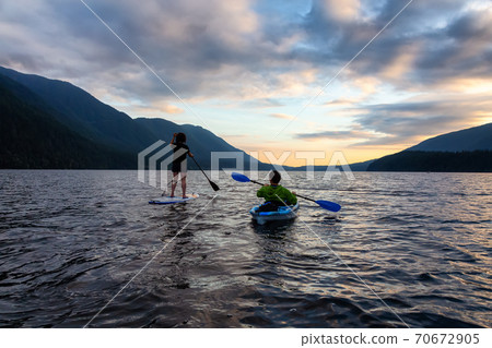 Friends on Scenic Lake Kayaking and Paddleboarding Together 70672905