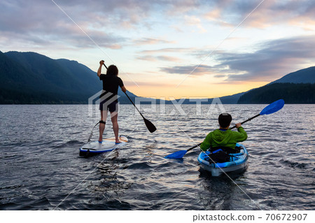 Friends on Scenic Lake Kayaking and Paddleboarding Together 70672907