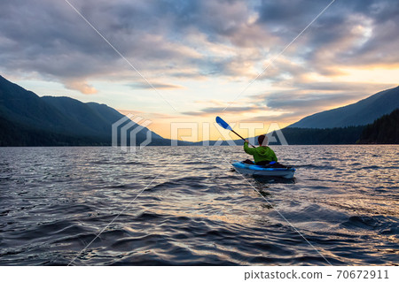 Beautiful View of Person Kayaking on Scenic Lake at Sunset 70672911
