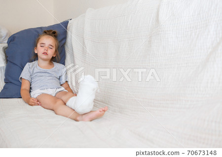 broken leg. Close-up of the cast on the feet. exercises to repair and strengthen muscles. damage to the bones. medical care of a surgeon in the emergency room 70673148