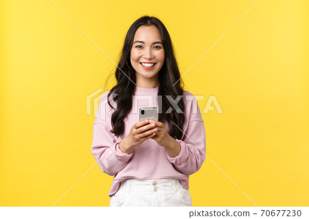 People emotions, lifestyle leisure and beauty concept. Smiling attractive young 20s woman using mobile phone. Girl making order from online shop using smartphone or using carsharing app People emotions, lifestyle leisure and beauty concept. Smiling attractive young 20s woman using mobile phone. Girl making order from online shop using smartphone or using carsharing app 70677230