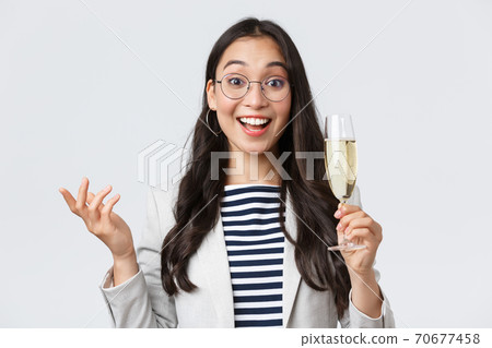 Business, finance and employment, female successful entrepreneurs concept. Enthusiastic happy businesswoman celebrating good deal, have office party with coworkers, make toast with glass champagne 70677458