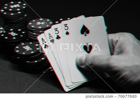 cards with two pairs in poker in the hands of a gambler on the background of gaming chips 70677680