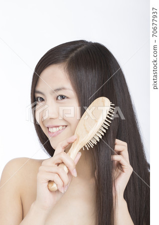 一個女人撫摸著她的頭髮 一個女人撫摸著她的頭髮 70677937
