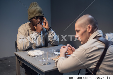 A young black criminal realizes what was done during the interrogation at the police station A young black criminal realizes what was done during the interrogation at the police station 70678014