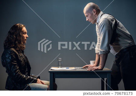 A police officer introduces the suspect to the details of the case A police officer introduces the suspect to the details of the case 70678173