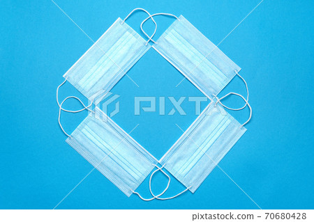 Stack of Disposable blue medical face masks on blue background 70680428