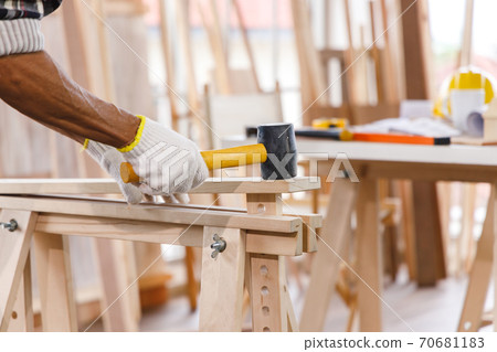 Carpenter use mallet on timber in carpentry workshop. Carpenter use mallet on timber in carpentry workshop. 70681183