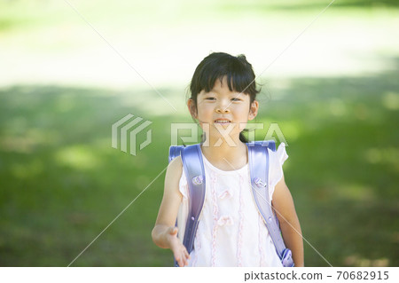 First grader carrying a school bag First grader carrying a school bag 70682915