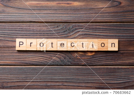 PROTECTION word written on wood block. PROTECTION text on cement table for your desing, concept 70683662