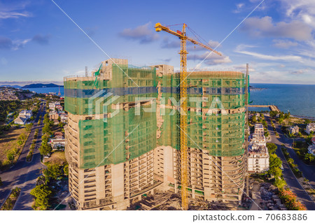 New buildings being constructed. Industrial building site. Shot of lifting crane and skyscraper under construction 70683886