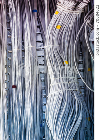 bunch of network cables in wave pattern leading across server ro 70684622
