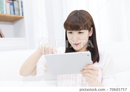 A woman watching a tablet PC A woman watching a tablet PC 70685757
