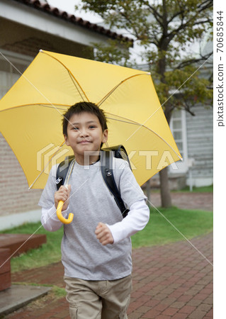 Elementary school student holding an umbrella 70685844