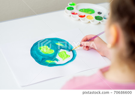 Little girl is drawing earth. Little girl is drawing earth. 70686600