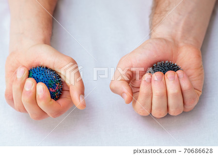 Rubber massage balls in hands. 70686628