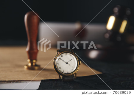 Notary stamp and wooden gavel with watch on the table. 70689059