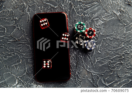 Casino play online concept. Playing chips, three dices and smartphone Casino play online concept. Playing chips, three dices and smartphone 70689075