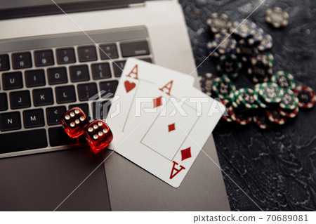 Chips, red dices and playing cards with aces for poker online or casino gambling on laptop keyboard. Online casino concept Chips, red dices and playing cards with aces for poker online or casino gambling on laptop keyboard. Online casino concept 70689081