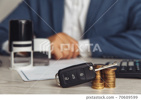 Car keys with contract on table. Warranty or guarantee. Customer or salesman 70689599