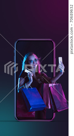 Beautiful woman inviting for shopping right from device screen, black friday, sales concept. Flyer with copyspace 70689632