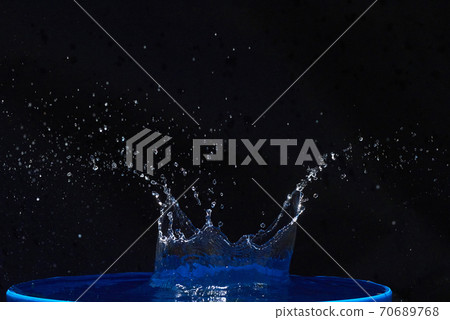 Splash of water crown on blue surface. Splash of water crown on blue surface. 70689768