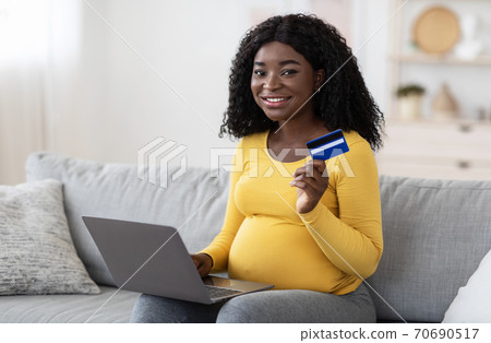 Mother shopping online with laptop and credit card 70690517