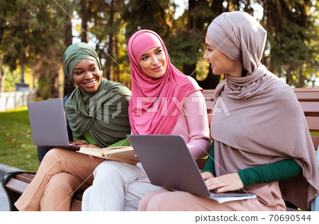 Three Isamic Ladies With Laptops And Books Learning In Park Three Isamic Ladies With Laptops And Books Learning In Park 70690544