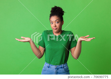 Confused puzzled black young lady shrugging at studio Confused puzzled black young lady shrugging at studio 70690775