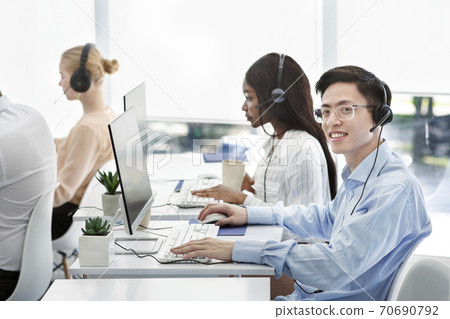 Group of positive technical support managers working on hotline at call centre Group of positive technical support managers working on hotline at call centre 70690792