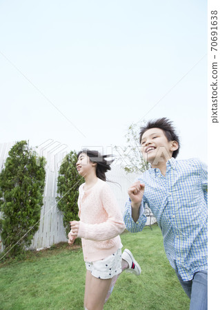 姐妹和兄弟在花園裡奔跑 70691638