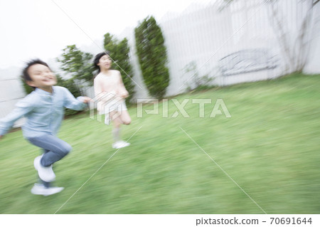 姐妹和兄弟在花園裡奔跑 70691644