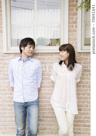 Men and women standing in front of the wall Men and women standing in front of the wall 70691841