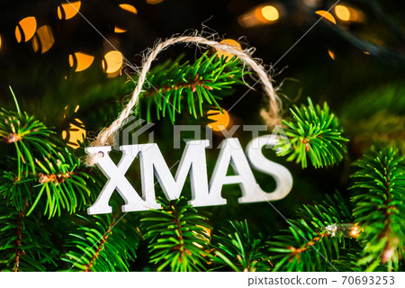 White wooden XMAS letters on the Christmas tree 70693253