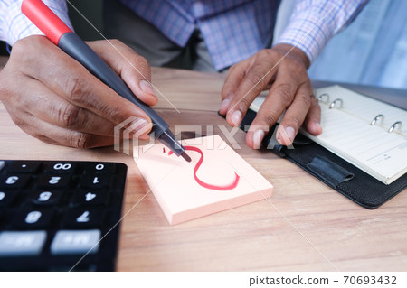 person hand drawing question mark on paper on office desk person hand drawing question mark on paper on office desk 70693432