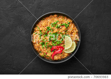 Baingan Bharta or Roasted Mashed Eggplant in black bowl on dark slate table top. Baingan Bharta or Roasted Mashed Eggplant in black bowl on dark slate table top. 70693983