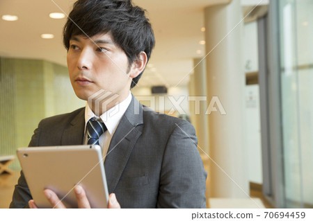Businesspeople watching Tablet PC 70694459
