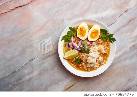Mohinga or Burmese Fish Noodle Soup in white plate on marble table top Mohinga or Burmese Fish Noodle Soup in white plate on marble table top 70694779