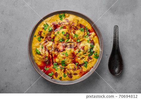 Punjabi Kadhi Pakora in gray bowl on concrete table top. Kadhi Pakoda is indian cuisine curry dish. 70694812