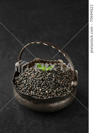 Black Gram or Urad Beans with green leaf in iron basket on slate table top. Indian cuisine food Black Gram or Urad Beans with green leaf in iron basket on slate table top. Indian cuisine food 70694822
