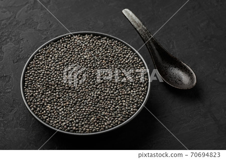Black Gram or Urad Beans or Mung Beans in bowl on dark slate table top. Vigna Mungo is popular indian cuisine food Black Gram or Urad Beans or Mung Beans in bowl on dark slate table top. Vigna Mungo is popular indian cuisine food 70694823