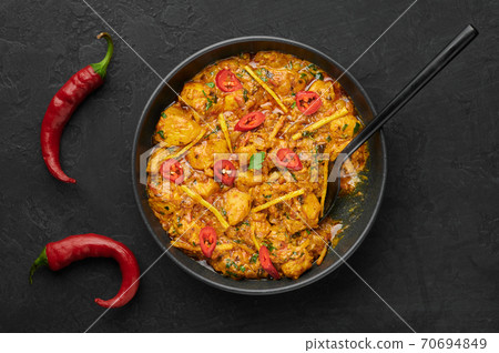 Chicken Handi in black bowl on dark slate table top. Murgh Chicken is indian cuisine curry Chicken Handi in black bowl on dark slate table top. Murgh Chicken is indian cuisine curry 70694849