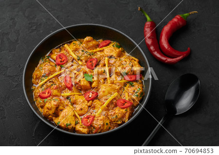Chicken Handi in black bowl on dark slate table top. Murgh Chicken is indian cuisine curry Chicken Handi in black bowl on dark slate table top. Murgh Chicken is indian cuisine curry 70694853
