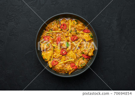 Chicken Handi in black bowl on dark slate table top. Murgh Chicken is indian cuisine curry Chicken Handi in black bowl on dark slate table top. Murgh Chicken is indian cuisine curry 70694854