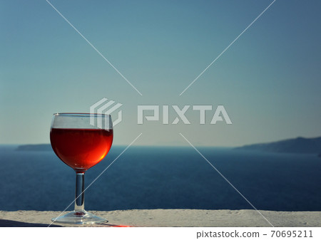 Glass of Red Wine with the Aegean Sea in the Background 70695211