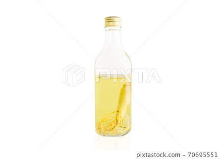Ginseng roots in the glass bottle isolated in white background. 70695551
