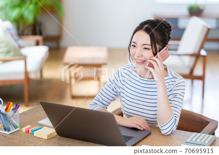 一個女人在客廳裡做遠程辦公。 一個女人在客廳裡做遠程辦公。 70695915